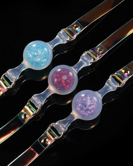 Foam_Handmade_Soft_Silicone_BDSM_Ball_Gag: Handmade BDSM ball gags (sex gags) crafted from soft silicone, showcasing iridescent straps and three shimmering color variants (blue, red, purple), blending artisanal design for kink play.