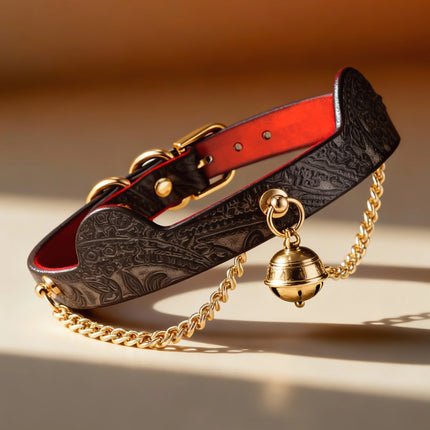Black embossed leather choker with red heat-reacitve interior leather, featuring a decorative gold jingle bell and hanging gold metal chains