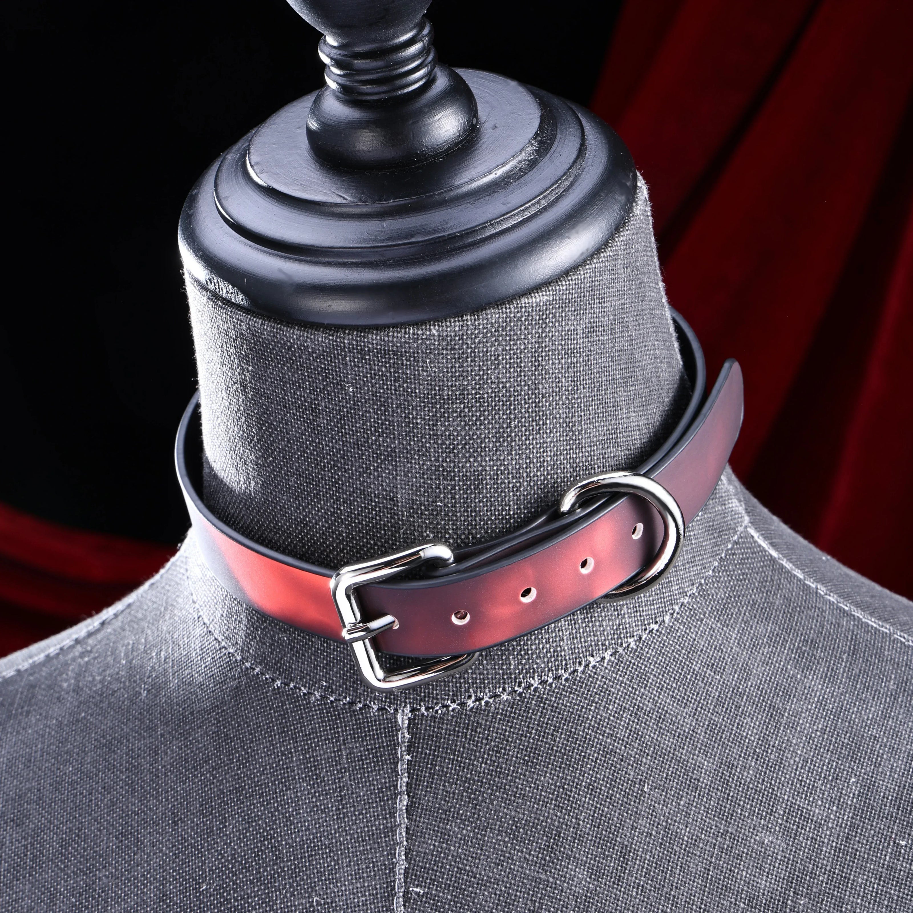 Red heat-reactive leather choker with a polished silver roller buckle and D-ring