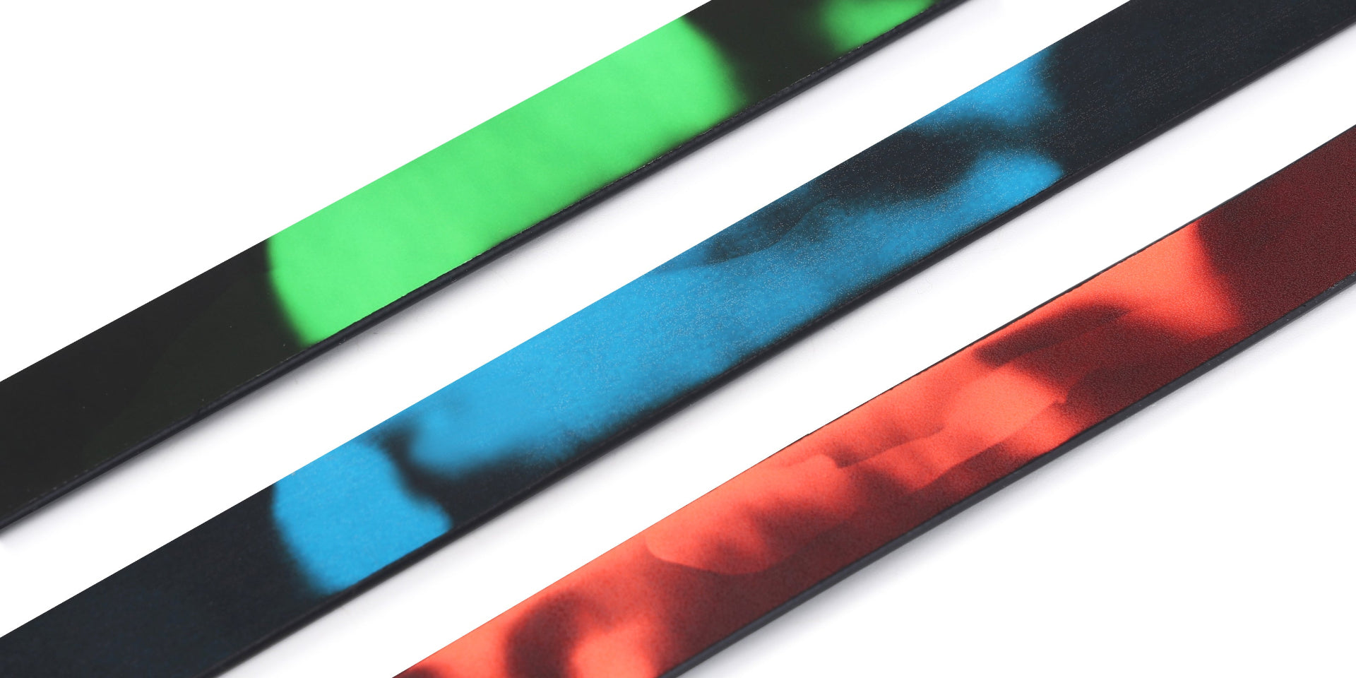 Three heat - reactive leathers after activation, placed side by side in parallel, displaying vibrant colors of green, blue, and red.