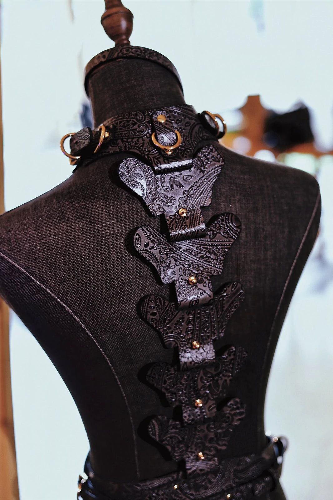 QIYE_Leather_Lagyeta_Harness_Banner: Back - view display of the harness on a mannequin, featuring intricate black leather patterns and metallic rings.